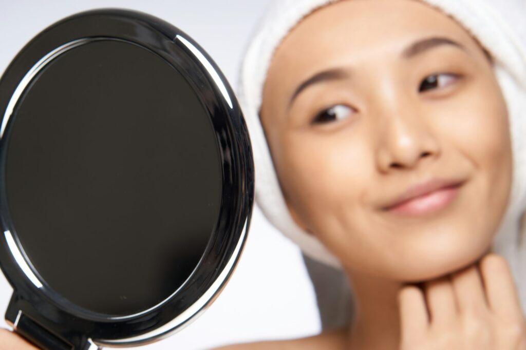 HydraFacial® pretty woman looking in the mirror healthy skin rejuvenation spa treatments