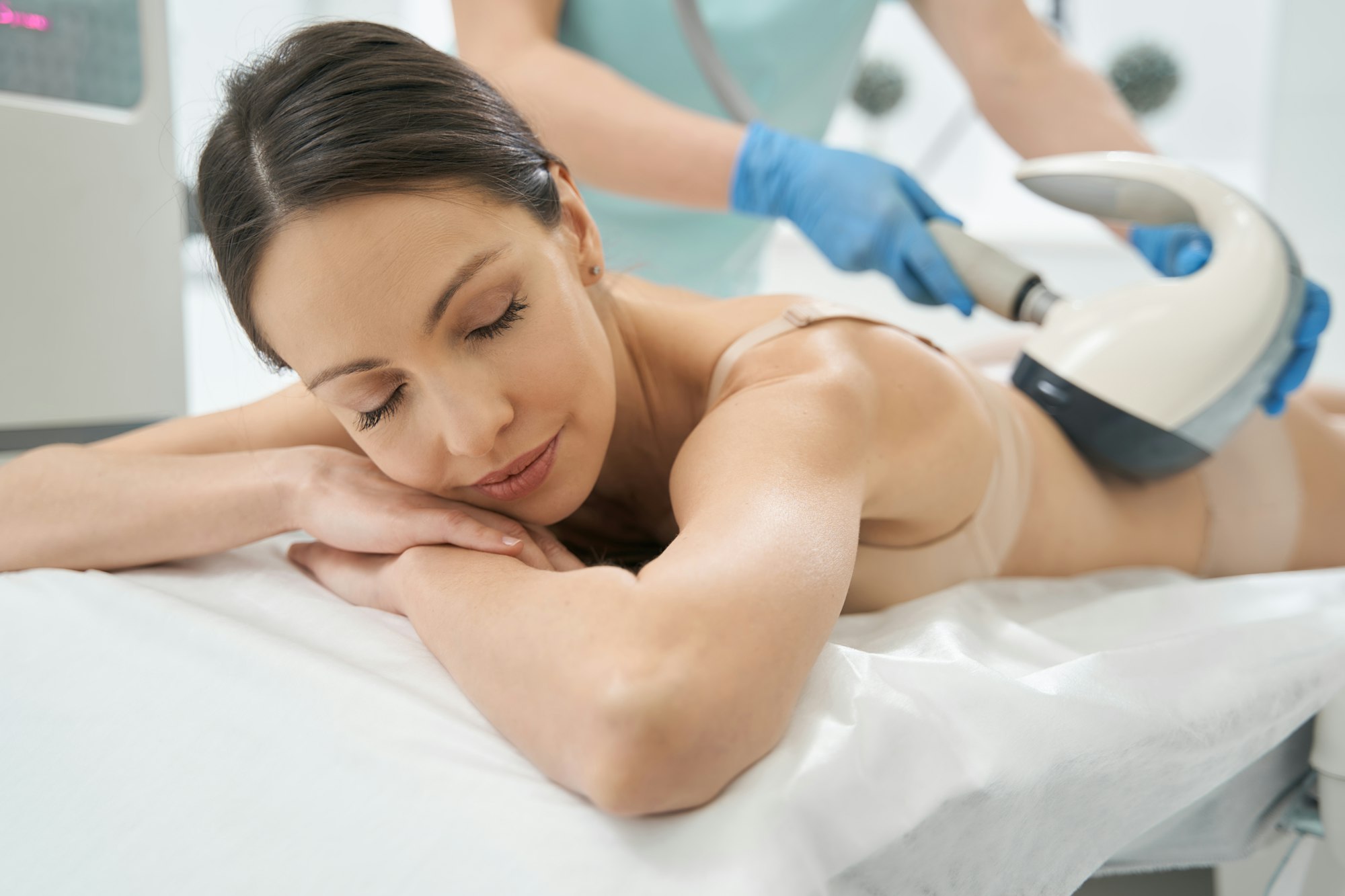 Woman with closed eyes taking pleasure in vela shape treatment